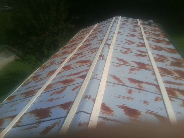 Rusted metal roof panels with new wood purlins before replacement — Storm Damage Roof Repair in Elmwood Park by Roofing Brothers